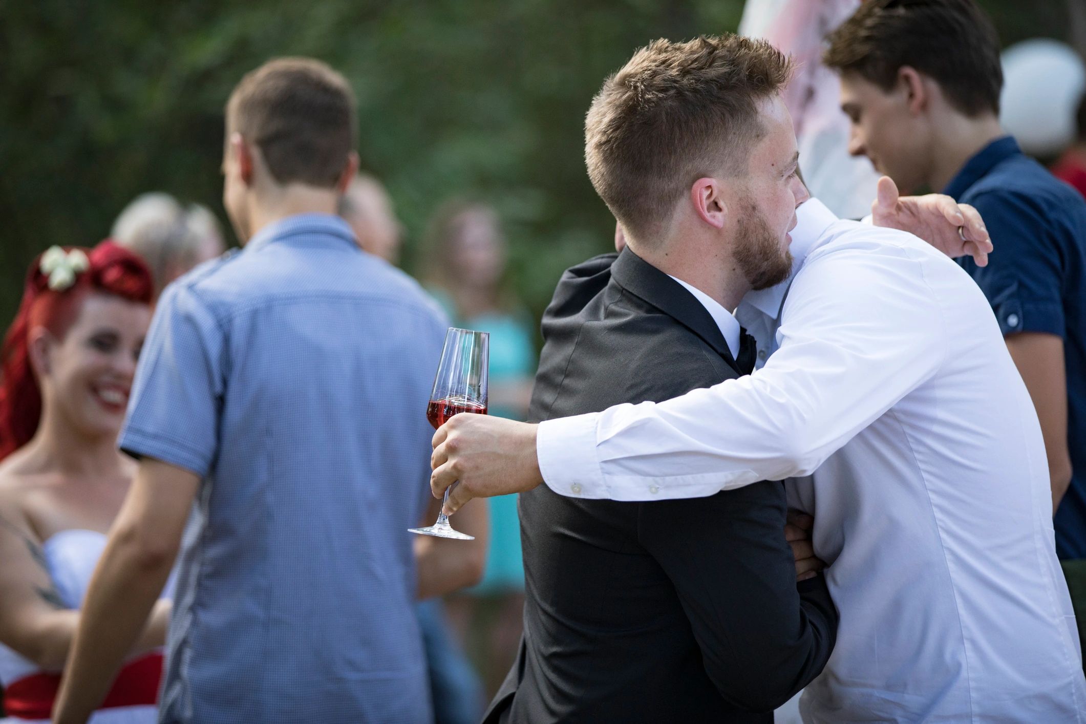 Friends congratulating the groom after a wedding ceremony