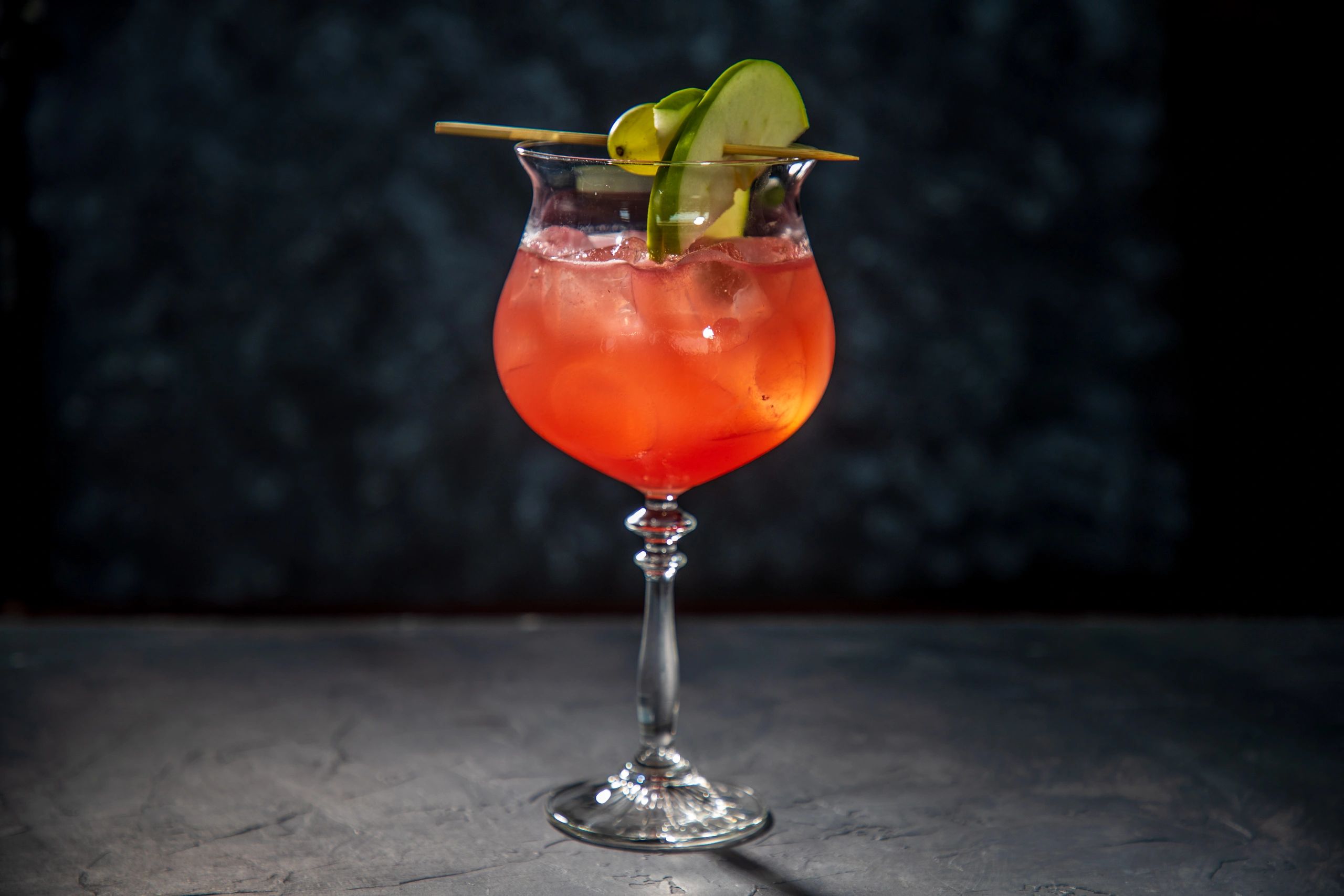 Close-up of a red craft cocktail with garnish