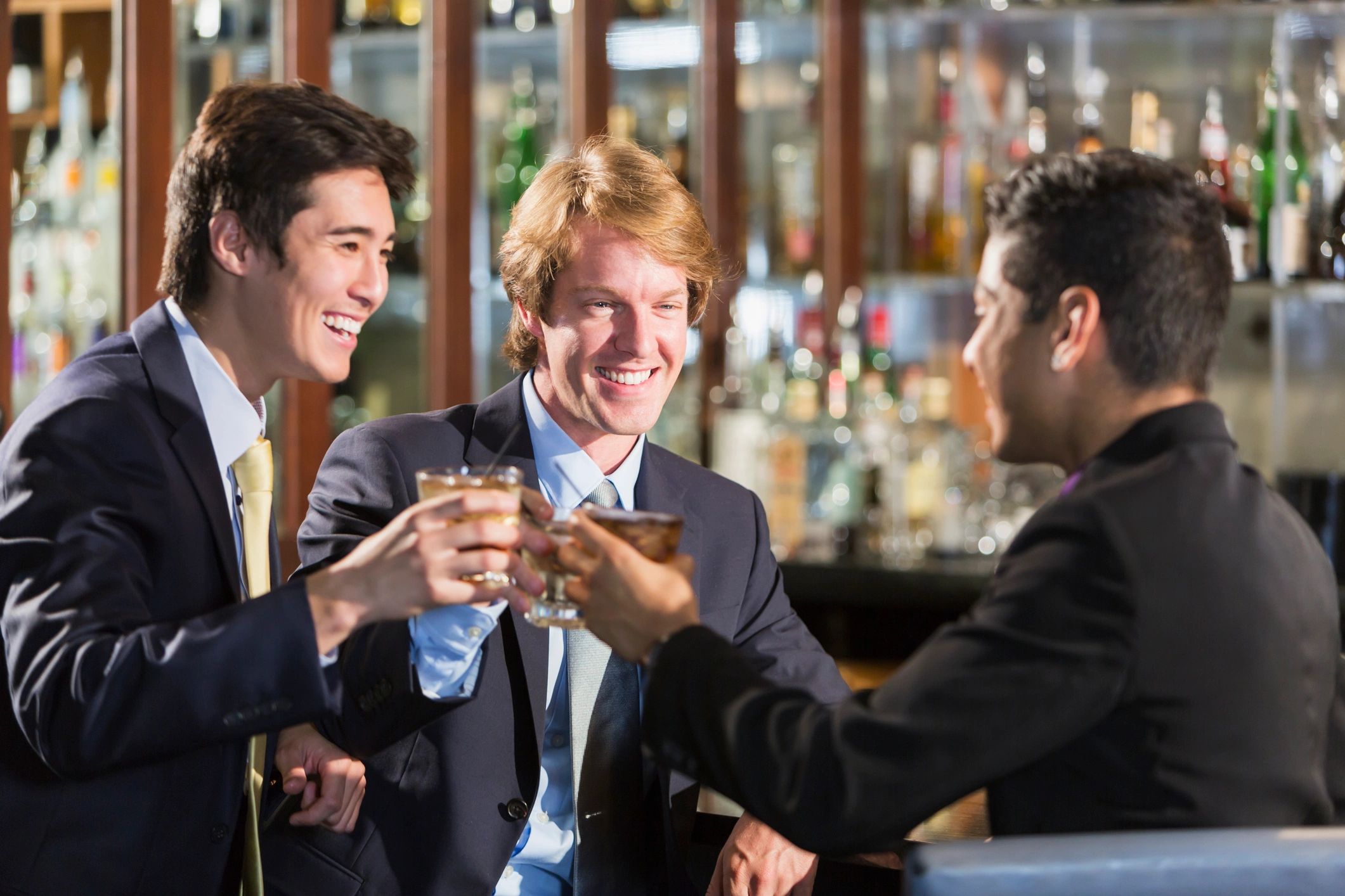 Three business professionals toasting at a bar